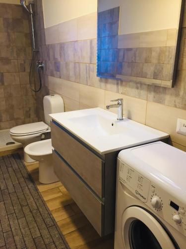 a bathroom with a sink and a washing machine at Etna home in Santa Venerina