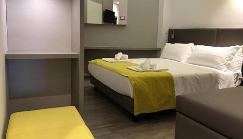 a hotel room with a bed with a yellow blanket at Hotel Montmartre in Rimini