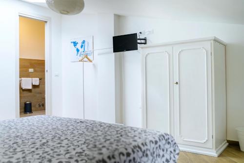 a bedroom with a bed and a tv on a wall at Le Voyageur Cilento in Vibonati