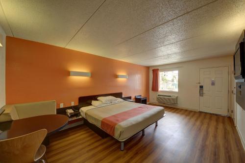 a bedroom with a bed and a desk and a table at Motel 6-San Antonio, TX - Downtown - Market Square in San Antonio