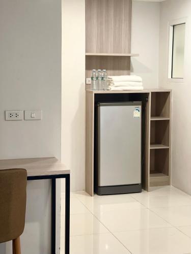 a kitchen with a small refrigerator and a table at BEAR’S DEN HOTEL PATTAYA in Jomtien Beach