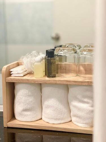 a shelf filled with white towels and other items at BEAR’S DEN HOTEL PATTAYA in Jomtien Beach