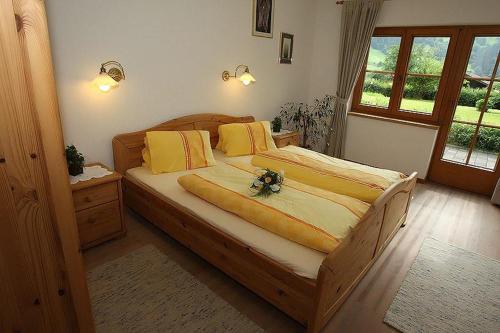 a bedroom with a wooden bed with yellow pillows at Ferienwohnungen Sunshine Stumm in Stumm