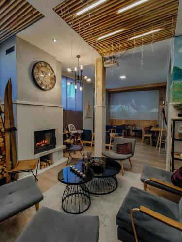 a living room with a fireplace and a clock at Casa di Pino EcoLodge Hotel in Žabljak