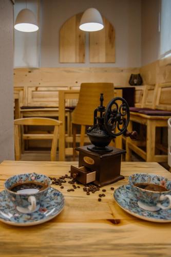 a table with two plates and a coffee maker on it at Casa di Pino EcoLodge Hotel in Žabljak