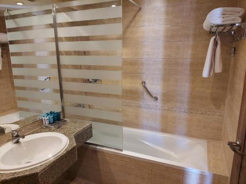 a bathroom with a shower and a sink and a tub at Sunrise Remal Resort in Sharm El Sheikh