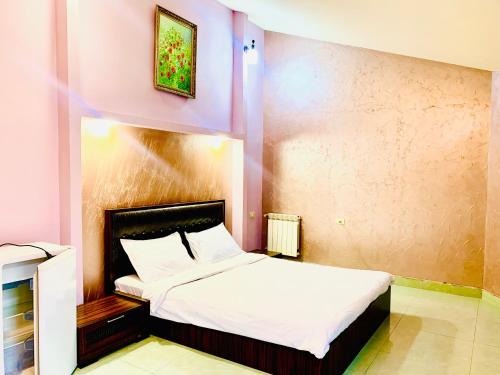 1 dormitorio con 1 cama grande con sábanas blancas en Art Hotel, en Ereván