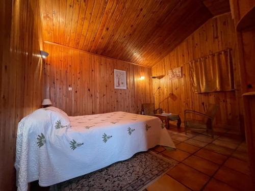 sypialnia z łóżkiem w drewnianym pokoju w obiekcie L'Es-sens-ciel w mieście Le Guillaume