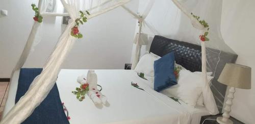 a bedroom with a white bed with a canopy at LEMON BEACH LODGE Vilankulo in Vilanculos
