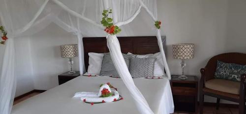 a bedroom with a white bed with christmas decorations on it at LEMON BEACH LODGE Vilankulo in Vilanculos