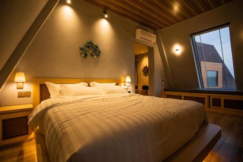 a bedroom with a large bed and a window at One of A Kind Resort @Trikora Beach - Bintan 