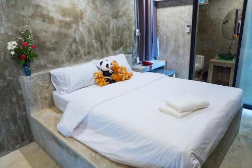 a bed with two teddy bears sitting on it at LOFT Zone by โรงแรมพรรณ in Ban Lahan Pa Phlu