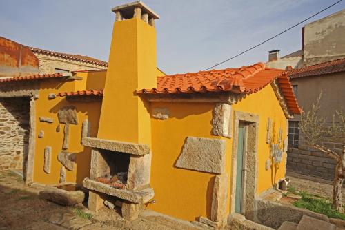 a yellow building with a tower on top of it at Curral de l Tiu Pino in Sendim