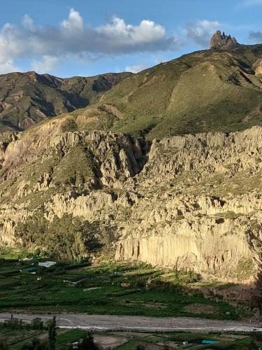 a large rocky mountain with a road in front of it at Colibrí Eco Lodge & Camping in La Paz