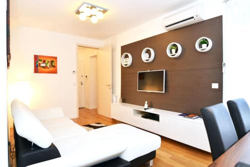 a living room with a white couch and a tv at Apartment Trnje in Zagreb