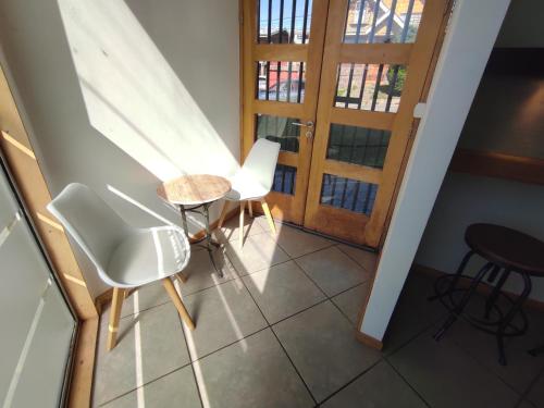 a room with a table and chairs and a door at Apart Hotel Quillango in Punta Arenas