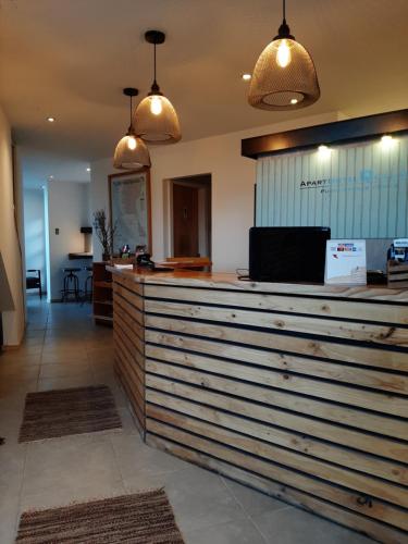 a bar in a restaurant with two pendant lights at Apart Hotel Quillango in Punta Arenas
