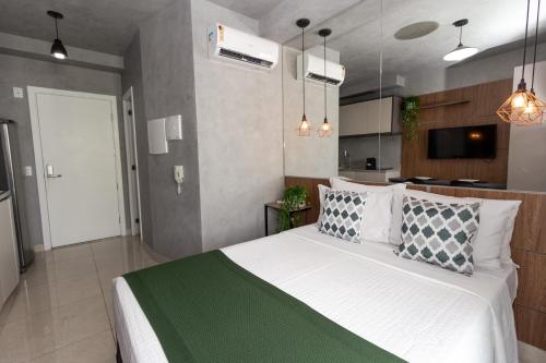 a bedroom with a large bed and a kitchen at 360 Suítes Sé in Sao Paulo