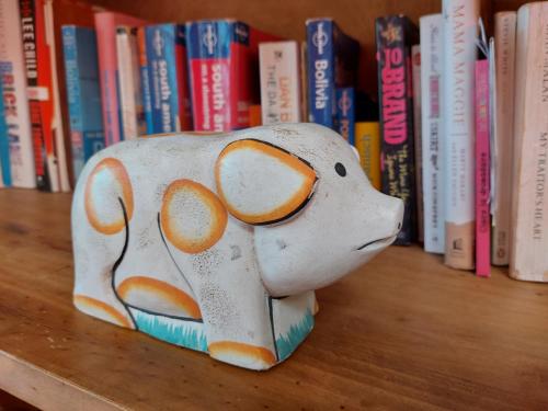 a figurine of a cow sitting on a book shelf at Colibrí Eco Lodge & Camping in La Paz