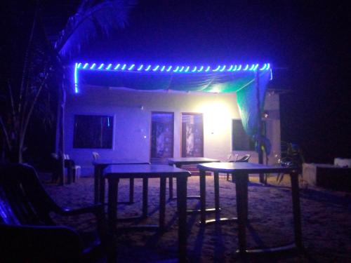duas mesas em frente a uma casa com luzes azuis em RV Homestay em Gokarna