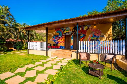 a pavilion with two chairs and a table in a yard at Zostel Plus Lonavala in Lonavala