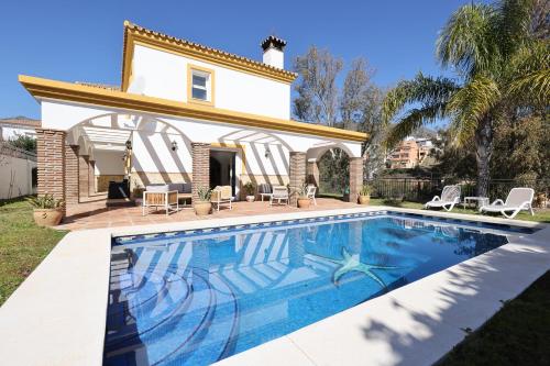 a swimming pool in front of a house at 088 Bright and Spacious Andalusian Style Villa With Private Pool in Fuengirola