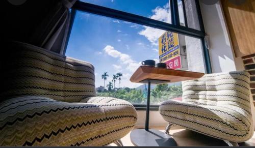 a room with two chairs in front of a window at See Hualien B&B in Hualien City