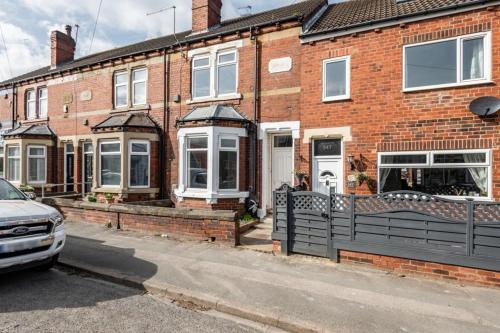 a brick house with a car parked in front of it at Hopetown Apartment-modern 2 bed with free parking in Normanton