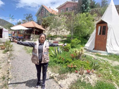 a woman standing with her arms out in a garden at Colibrí Eco Lodge & Camping in La Paz
