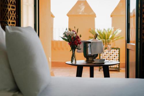 a table with a vase of flowers on top of a bed at Alhambra Palace Hotel in Granada