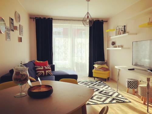a living room with a table and a blue couch at Belle View Apartment Brasov in Braşov