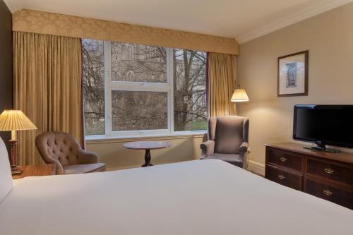 a hotel room with a bed and a large window at Winchester Wessex Hotel by Sunday in Winchester
