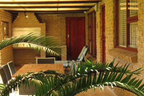 a patio with a table and chairs and a red door at Lake Brenton Paradise in Knysna