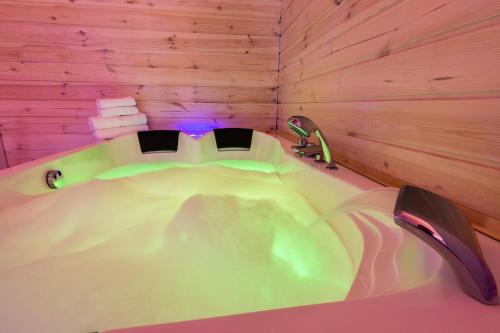 bañera en una habitación con pared de madera en Melody De Luxe Apartment, en Michałowice