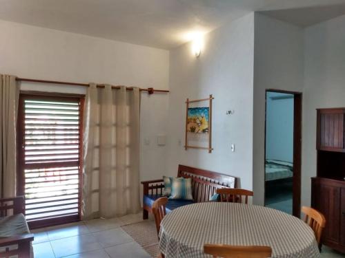 une salle à manger avec une table et des chaises et une fenêtre dans l'établissement Chalé Pitanga, à São Miguel do Gostoso