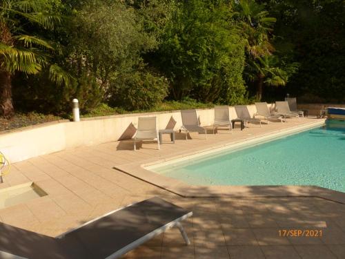 a row of lounge chairs next to a swimming pool at Suite 22 in Aix-les-Bains