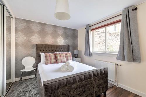 a bedroom with a bed with two towels on it at Stunning 1 Bed at Holyrood Palace & Arthurs Seat in Edinburgh
