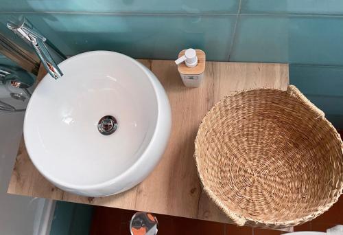 a bathroom with a white sink and a basket at Cozy Beach House in Santa Luzia