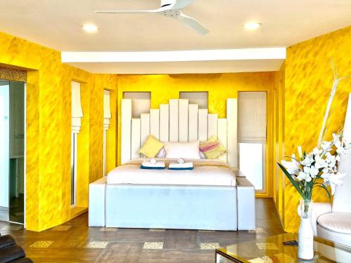 a bedroom with a white bed with yellow walls at Best world vision in Chaweng