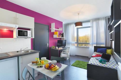 a kitchen and a living room with a table in a room at Résidence Néméa Villeneuve Métropole in Villeneuve d'Ascq