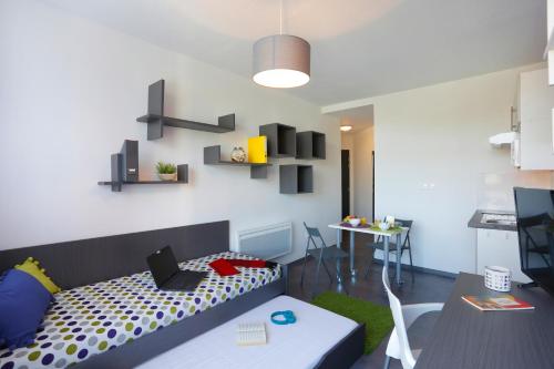 a room with a bed with a laptop on it at Résidence Nemea Villeneuve Métropole in Villeneuve d'Ascq