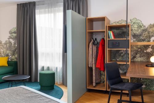 a bedroom with a bed and a desk and a table at Hôtel Du Dragon in Strasbourg