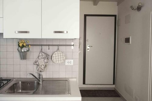 cocina con fregadero y puerta a la cocina en Via de' Falegnami 6 Apartment by Wonderful Italy, en Bolonia