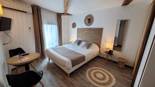 a hotel room with a bed and a table and a table sidx sidx at Le Relais du Valois, Cognac Centre in Cognac