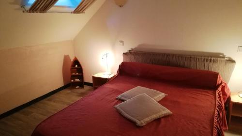 - une chambre avec un lit rouge et 2 oreillers dans l'établissement Maison de 2 chambres avec jardin amenage et wifi a Questembert, à Questembert