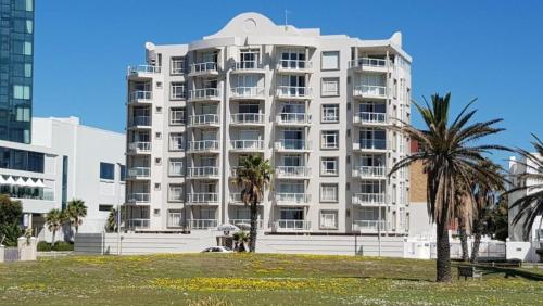 un grande edificio bianco con palme di fronte di Cascades 103 a Port Elizabeth