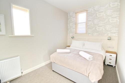 a bedroom with a bed with two towels on it at CarterCo Rooms in Portsmouth