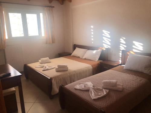 two beds in a room with towels on them at Zotos Studios in Vasiliki