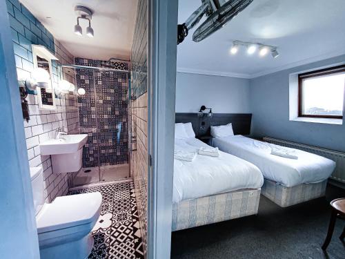 a hotel room with two beds and a shower at Plaza Hotel in London