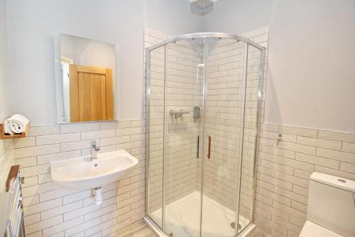 a bathroom with a glass shower and a sink at CarterCo Rooms in Portsmouth